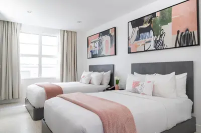 two beds in a hotel room with white walls at Clevelander Hotel in Miami Beach