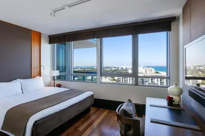 a hotel room with a bed and large windows at The Setai, Miami Beach in Miami Beach