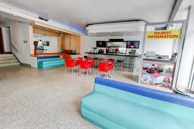 a waiting room with red chairs and a counter at Parisian Hotel in Miami Beach