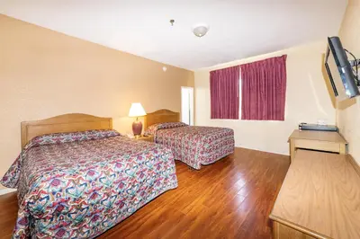 a hotel room with two beds and a flat screen tv at Parisian Hotel in Miami Beach
