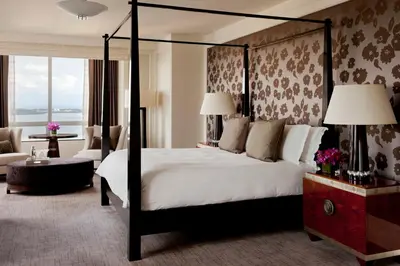 a bedroom with a four poster bed and a living room at Four Seasons Hotel Miami in Miami
