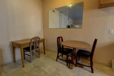 two tables and chairs in a room with a mirror at Geneva Hotel in Miami Beach