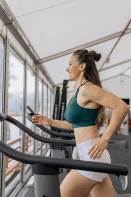 a woman running on a treadmill in a gym at Nassau Suite South Beach, an All Suite Hotel in Miami Beach