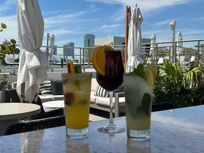 three cocktails sitting on a table on a balcony at Nassau Suite South Beach, an All Suite Hotel in Miami Beach