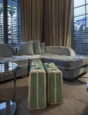 a living room with a couch and two suitcases at Shepley South Beach Hotel in Miami Beach