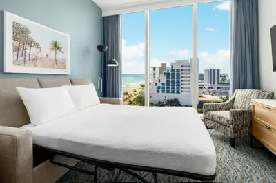 a bedroom with a bed and a large window at Courtyard by Marriott Oceanside Fort Lauderdale Beach in Fort Lauderdale