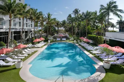 an overhead view of a swimming pool with lounge chairs and umbrellas at Cadillac Hotel & Beach Club, Autograph Collection in Miami Beach