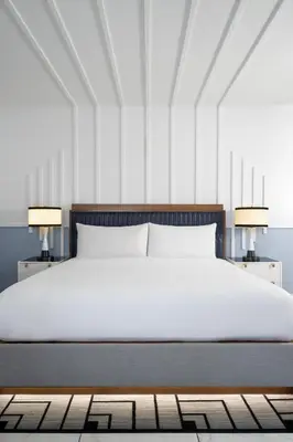 a bedroom with a white bed and two lamps at Cadillac Hotel & Beach Club, Autograph Collection in Miami Beach