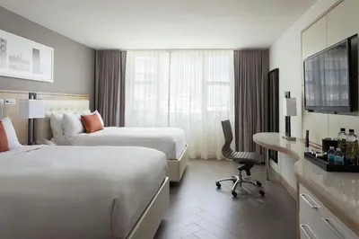 a hotel room with two beds and a desk at Marriott Stanton South Beach in Miami Beach