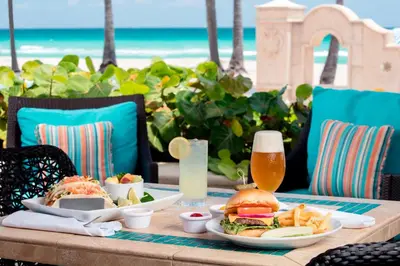 a table with a sandwich and fries and a glass of beer at Hollywood Beach Marriott in Hollywood