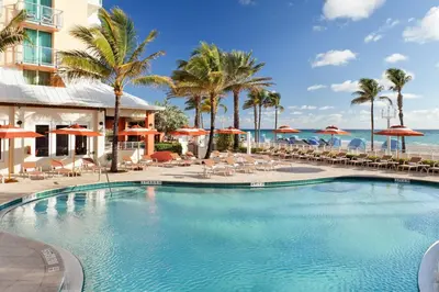 a swimming pool at a resort with chairs and umbrellas at Hollywood Beach Marriott in Hollywood