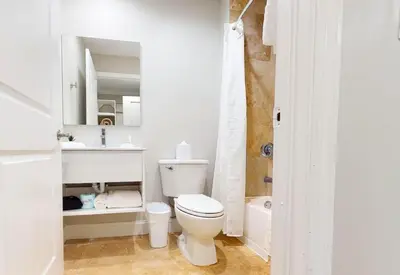 a white bathroom with a toilet and a sink at Nuvo Suites Hotel - Miami Doral in Miami