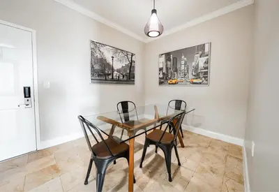 a dining room with a glass table and chairs at Nuvo Suites Hotel - Miami Doral in Miami