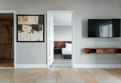 a living room with a television and a white wall at Nuvo Suites Hotel - Miami Doral in Miami