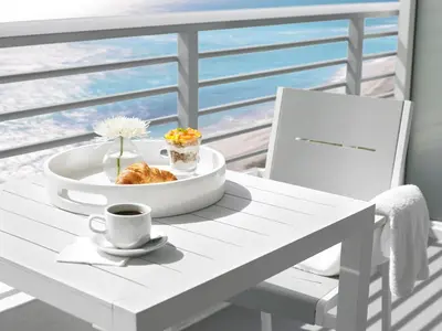 a white table with a bowl of food and a cup of coffee at Grand Beach Hotel in Miami Beach