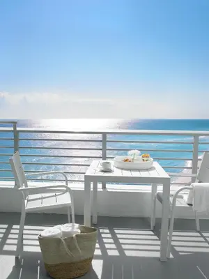 a white table and chairs on a balcony with the ocean at Grand Beach Hotel in Miami Beach