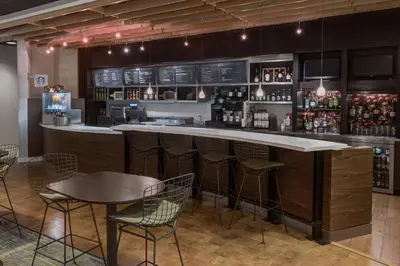 a bar in a restaurant with chairs and tables at Courtyard by Marriott Miami West/FL Turnpike in Miami