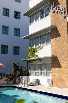 a hotel with a swimming pool in front of a building at Crest Hotel Suites in Miami Beach
