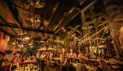 a group of people sitting at tables in a restaurant at Liberty Park Hotel South Beach in Miami Beach