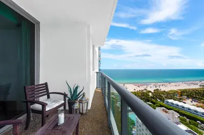 a balcony with a chair and a view of the beach at Oceanview Private Condo at The Setai -2402 in Miami Beach