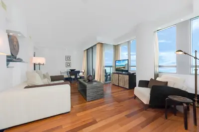 a living room with a white couch and a tv at Oceanview Private Condo at The Setai -2402 in Miami Beach