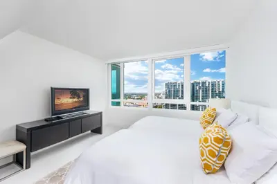 a white bedroom with a bed and a television at 4B Super Premium Private Condo at the Setai in Miami Beach