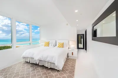 a white bedroom with a bed and large windows at 4B Super Premium Private Condo at the Setai in Miami Beach