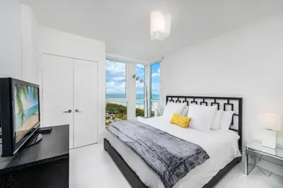 a white bedroom with a bed and a television at 4B Super Premium Private Condo at the Setai in Miami Beach