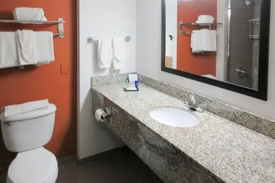 a bathroom with a toilet and a sink with a mirror at Sleep Inn & Suites Ft Lauderdale International Airport in Dania Beach