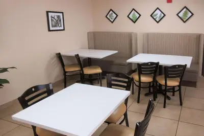 a dining room with white tables and chairs at Sleep Inn & Suites Ft Lauderdale International Airport in Dania Beach