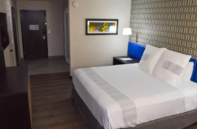 a hotel room with a large bed and a hallway at Best Western Plus Ft Lauderdale Hollywood Airport Hotel in Hollywood