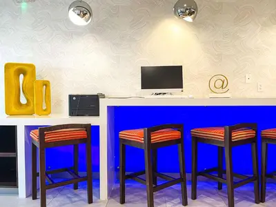 a bar with three stools in front of a blue counter at Best Western Plus Ft Lauderdale Hollywood Airport Hotel in Hollywood