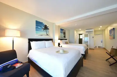 a hotel room with two beds and a couch at Sun Tower Hotel & Suites on the Beach in Fort Lauderdale
