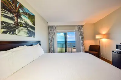 a bedroom with a bed and a window with the ocean at Sun Tower Hotel & Suites on the Beach in Fort Lauderdale