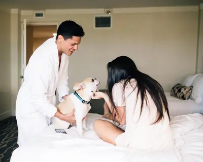 a man and woman sitting on a bed with a dog at InterContinental Miami by IHG in Miami