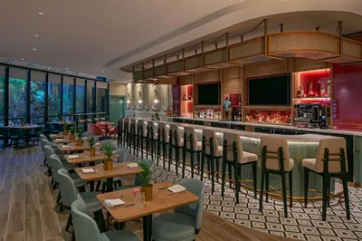 a restaurant with tables and chairs and a bar at Sonesta Miami Airport in Miami