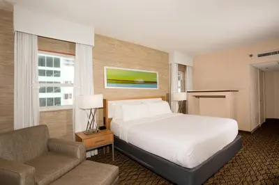 a bedroom with a bed and a couch and a chair at Holiday Inn Miami Beach-Oceanfront by IHG in Miami Beach