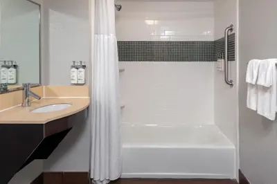 a bathroom with a tub and a shower with a sink at Staybridge Suites Miami Doral Area by IHG in Miami