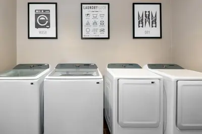 three washing machines in a laundry room with pictures on the wall at Staybridge Suites Miami Doral Area by IHG in Miami