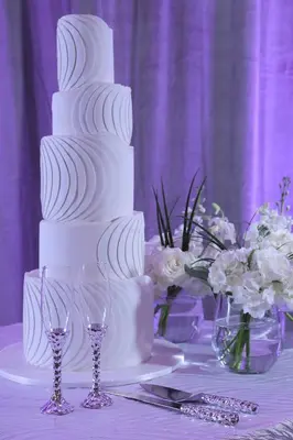 a white wedding cake on a table with wine glasses at InterContinental At Doral Miami by IHG in Miami