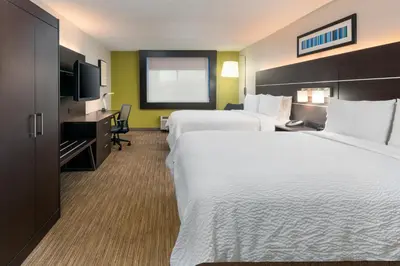 a hotel room with two beds and a television at Holiday Inn Express Miami Airport Doral Area by IHG in Miami