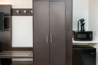 a kitchen with brown cabinets and a microwave at Holiday Inn Express Miami Airport Doral Area by IHG in Miami