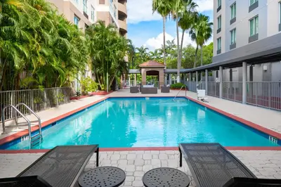 a swimming pool with a gazebo next to a building at Holiday Inn Miami-Doral Area by IHG in Miami