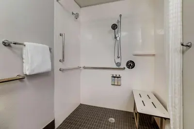 a white bathroom with a shower and a sink at Sonesta Simply Suites Miami Airport Doral in Miami