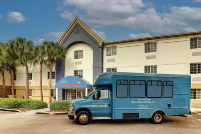a blue van parked in front of a building at Sonesta Simply Suites Miami Airport Doral in Miami