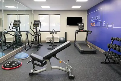 a gym with several exercise bikes and a tv at Holiday Inn Express Hotel & Suites Kendall East-Miami by IHG in Kendall