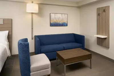 a living room with a blue couch and a chair at Holiday Inn Express Hotel & Suites Kendall East-Miami by IHG in Kendall