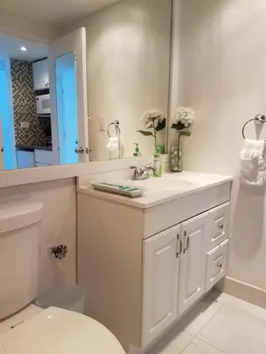 a bathroom with a sink and a toilet and a mirror at L&D Vacations Rentals in Miami Beach