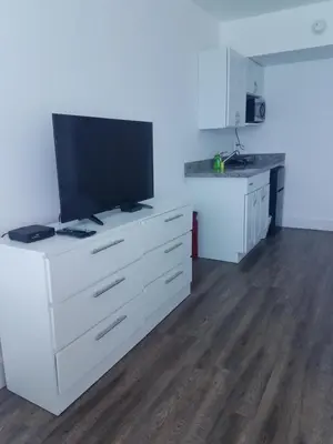 a living room with a television on a white dresser at L&D Vacations Rentals in Miami Beach