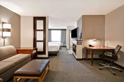 a hotel room with a couch and a table and a bed at Hyatt Place Miami Airport-West/Doral in Miami